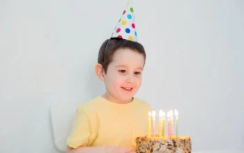 crianca-no-bolo-de-aniversario-de-chapeu-de-festa_255880-2354